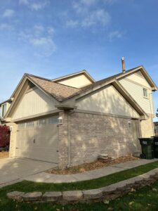 Rear view of a white and gray house with a garage